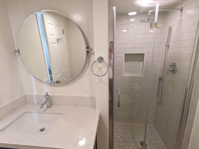 Bathroom — Frameless glass shower, hex tile floor, recessed niche